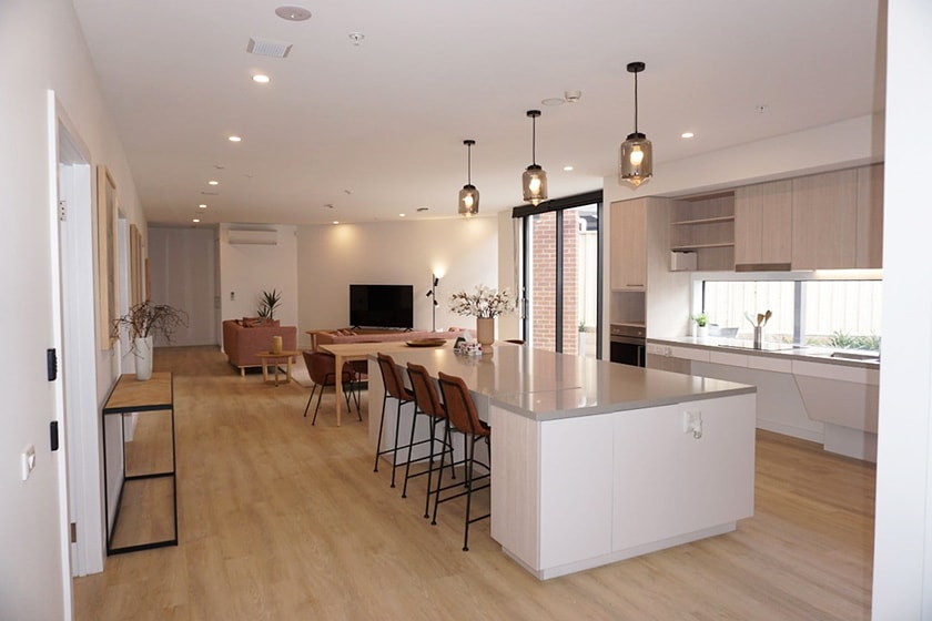 A large, modern entertaining area with kitchen and breakfast bench, and a lounge and TV.