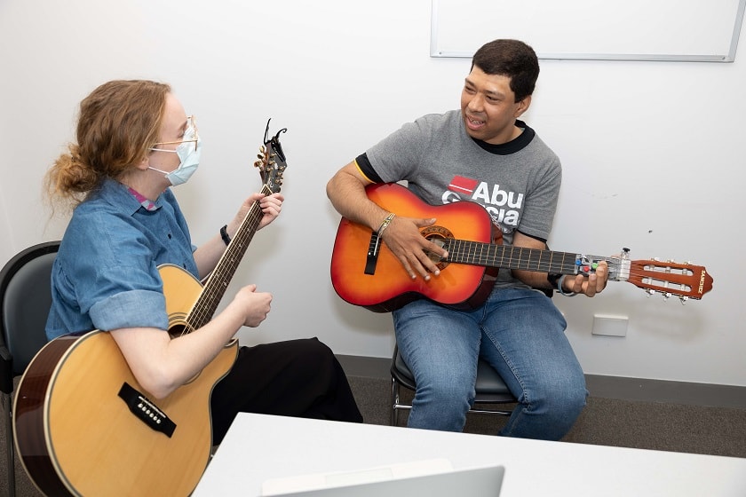 Two people playing guitar.