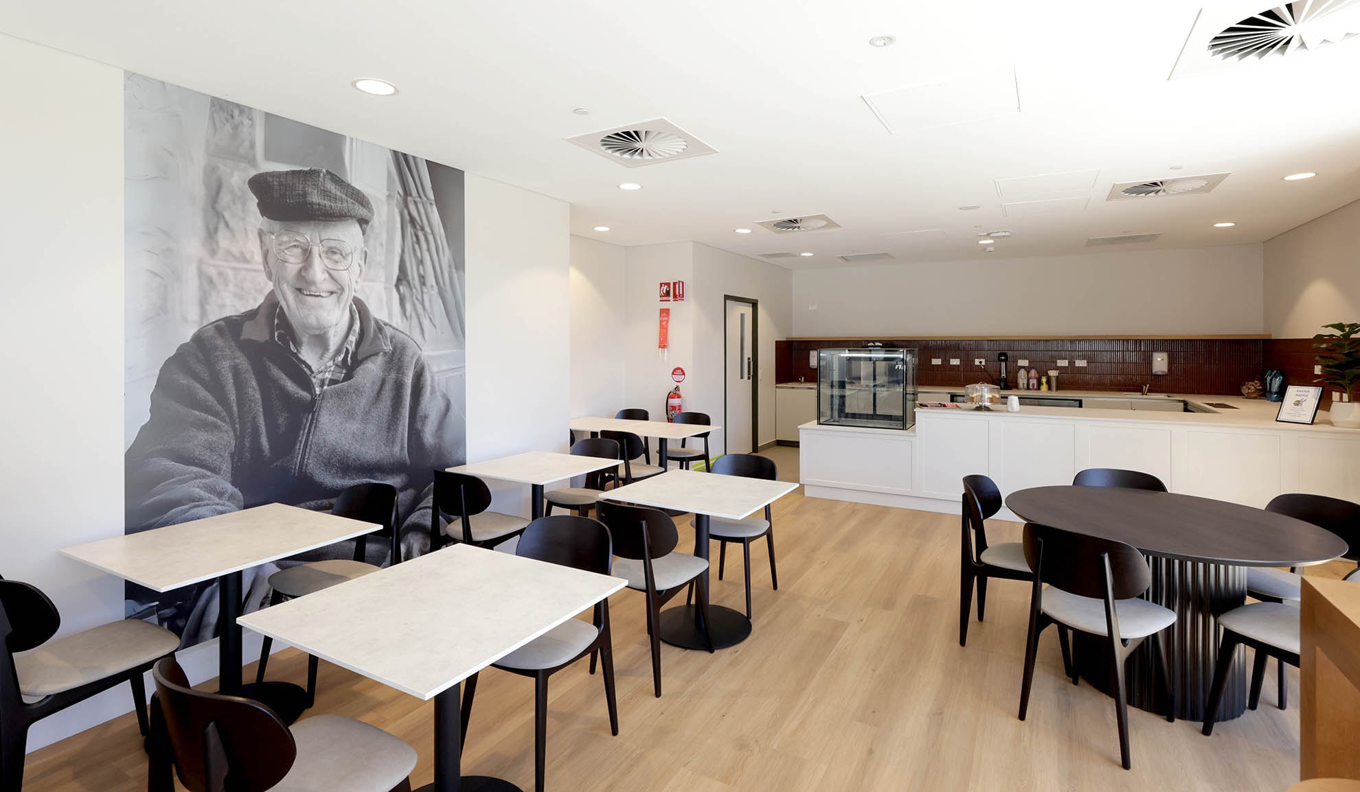 St John of God Richmond Hospital redevelopment cafe with glass cabinet, table seating and artwork on wall