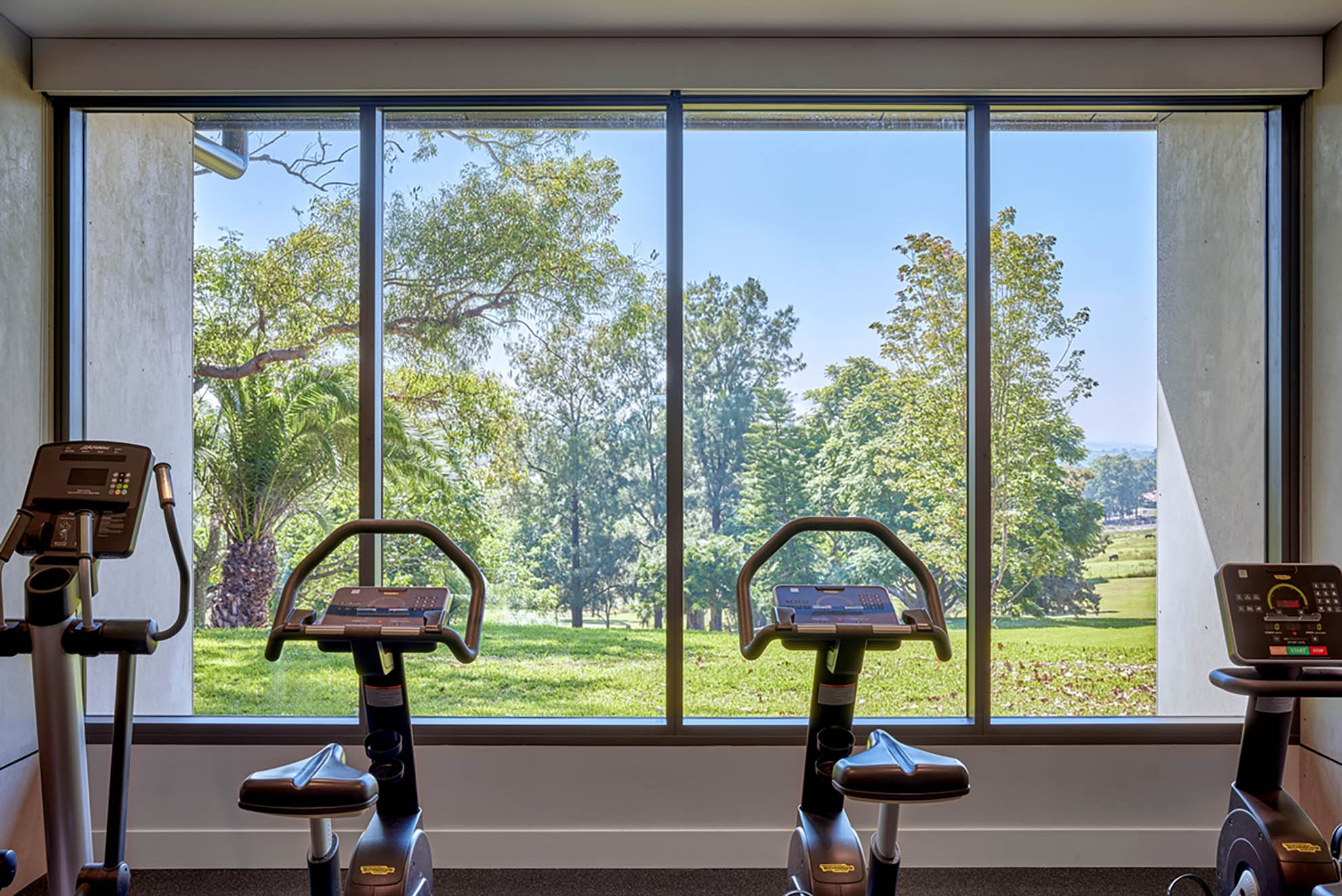 St John of God Richmond Hospital redevelopment gym with exercise bikes facing full height window overlooking trees and grassy hill