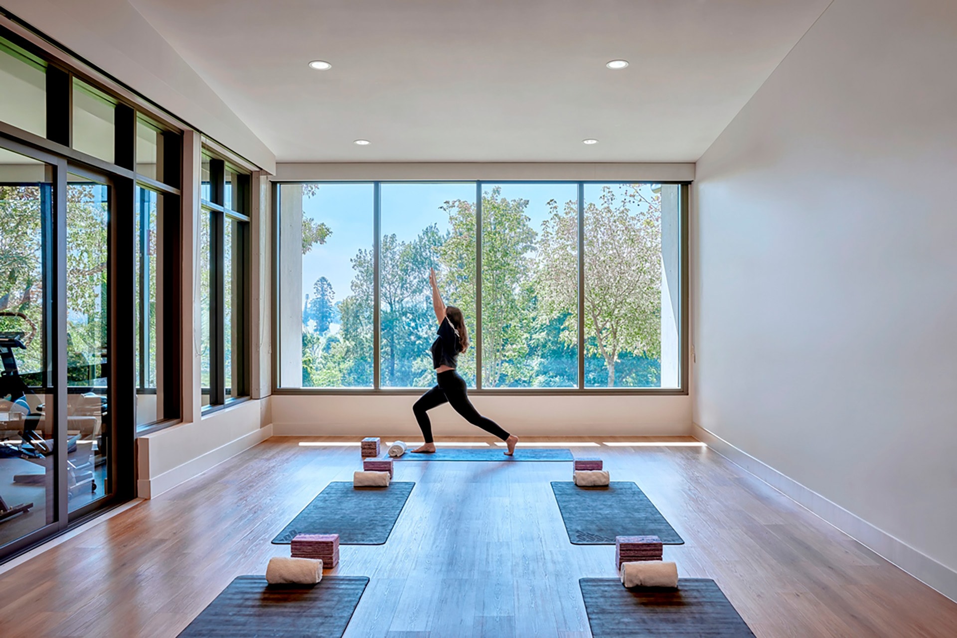 St John of God Richmond Hospital redevelopment young woman poses in yoga room with yoga mats laid out on floorboards