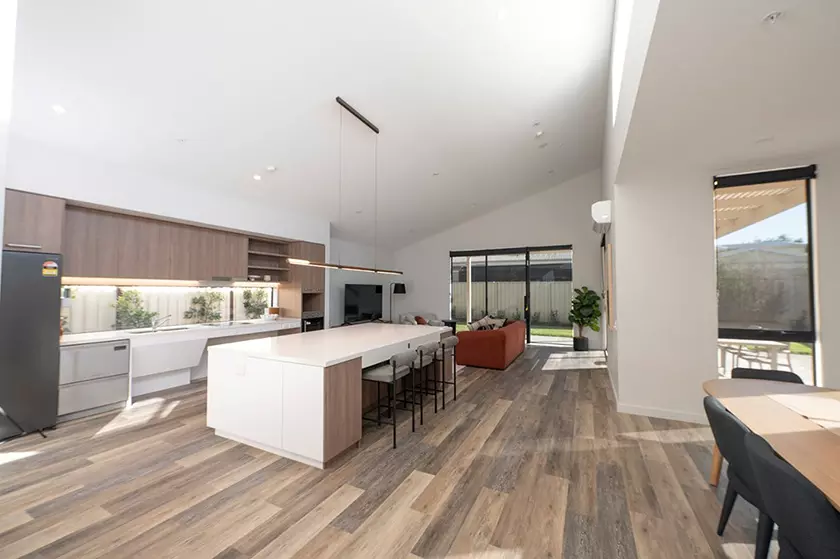 A large living area with high ceilings and a big kitchen.